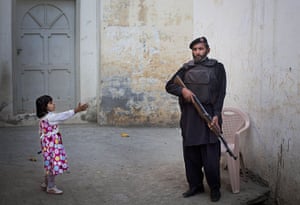 20 Photos: A young girl reaches out to a Pakistani policeman