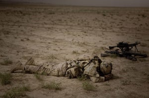 20 Photos: A Canadian soldier rests next to his guns in Khebari Ghar, Afghanistan