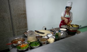A chef prepares food at a canteen inside a supermarket in Pyongyang, July 2013