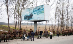 Troops mingle with an advertising hoarding near the airport in Pyongyang.