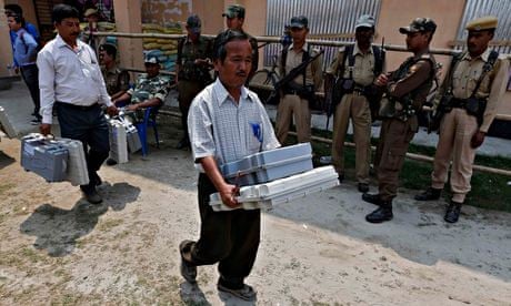 Indian election officials carry voting machines