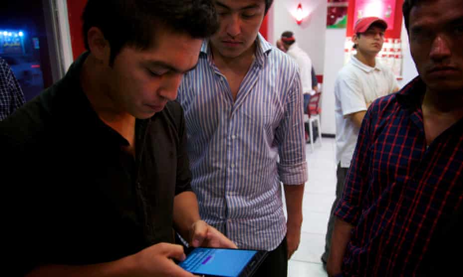A man checks his email on his smart phone in Kabul's frozen yogurt establishment.