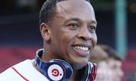 Dr Dre smiles broadly with a pair of Beats headphones round his neck