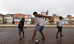 Children play football in the Manguinhos slums in Rio de Janeiro