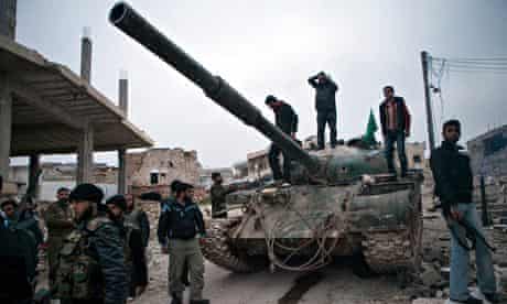 Syrian rebels gather around a T-72 tank, captured from government forces in the village of Kfarruma