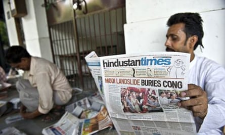 A Delhi resident reads a newspaper with the BJP’s election victory on the front