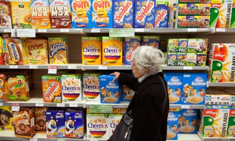 Elderly woman buying breakfast cereals from supermarket shelves,UK, on 27 November 2011.