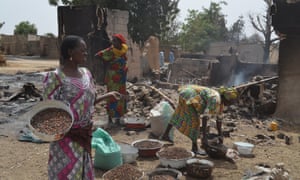 Women gather in front of a burnt-out house in Mainok, outside Maiduguri in Borno State. At least 74 people were killed in attacks on 1 March 2014 in villages near Maiduguri, blamed on Boko Haram militants.