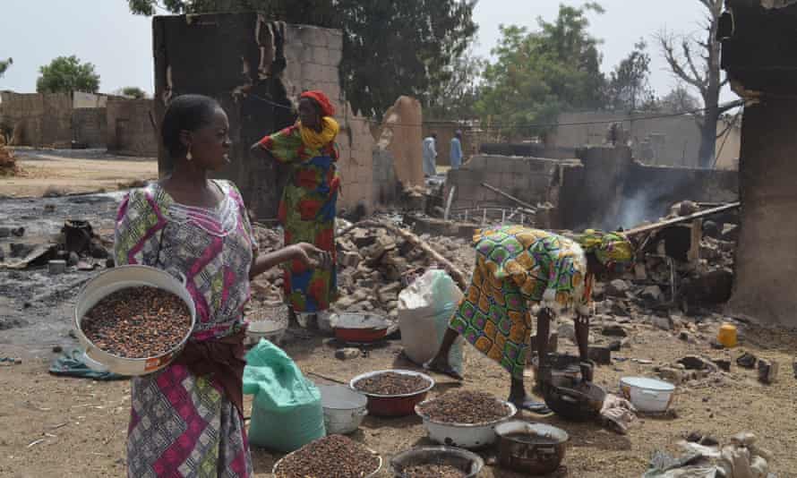 Women gather in front of a burnt-out house in Mainok, outside Maiduguri in Borno State. At least 74 people were killed in attacks on 1 March  2014 in villages near Maiduguri, blamed on Boko Haram militants.