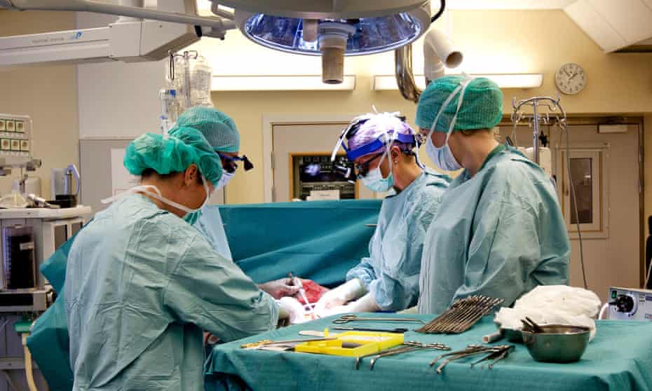 Four Doctors performing surgery in theatre