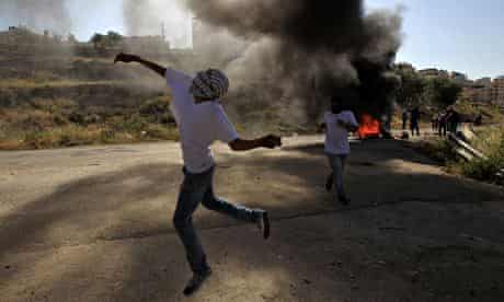 A Palestinian throws a stone during clashes with Israeli security forces outside Ofer prison