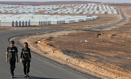 'A ghost city of white boxes' … Neil Gaiman and Georgina Chapman outside Azraq camp.