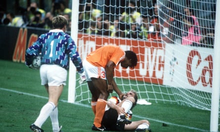 Frank Rijkaard encourages Rudi Voeller to get up after an angry confrontation in the box.