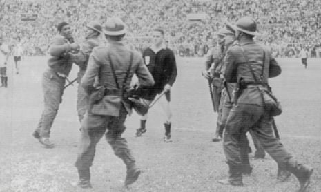 24 May 1964, Lima, Peru: Police restrain an angry football fan at the Estadio Nacional after a disallowed goal