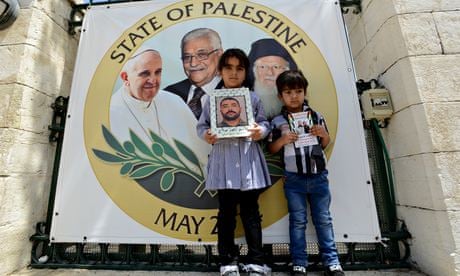 Palestinian children hold pictures of loved ones held in Israeli prisons before Pope Francis's visit
