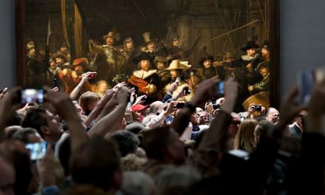 Visitors raise their cameras and mobile phones in front of Dutch master Rembrandt's The Night Watch
