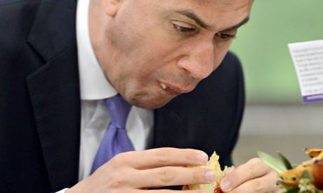 Ed Miliband tucks into a bacon sandwich on a morning trip to buy flowers for his wife.