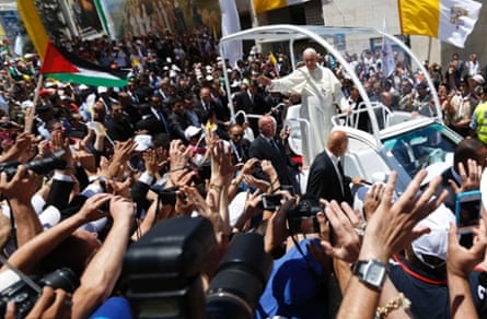Pope Francis waves to the crowds at Manger Square. He invited the Israeli and Palestinian presidents to come to the Vatican to pray for peace a month after US-backed talks aimed at ending the Middle East conflict collapsed.