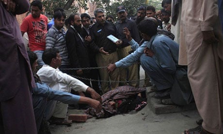 Police collect evidence near the body of Farzana Iqbal outside the Lahore high court building