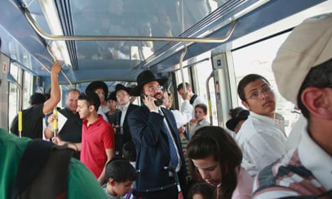 Passengers ride a light rail train in Jerusalem. The route means many of the city's divided residents have to at least tolerate each other for a short journey.