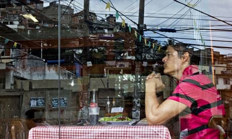 A diner at Bar Lacubaco in the Vidigal favela, reflected in the window. Photograph: Victor R Caivano