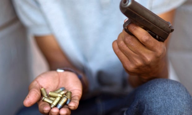 A young gang member shows a gun and ammunition, in Bonteheuwel neighbourhood in Cape Town in 2012.