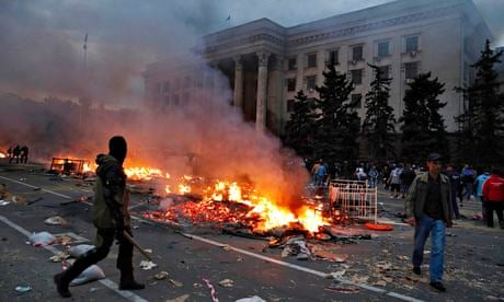 A protester walks past a burning pro-Russia tent camp near the trade union building in Odessa