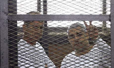 Al-Jazeera journalists Peter Greste and Mohamed Famy in a cage in a court in Cairo, Egypt