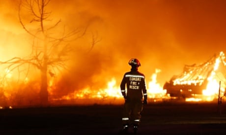 An Edmond firefighter looks at a fire raging in a mobile home park in Oklahoma on Sunday. Wildfires have become more prevalent in the US because of climate change.