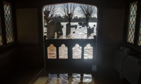 Gravestones surrounded by floodwater in the grounds of St Deny's Church in Severn Stoke, Worcestershire.