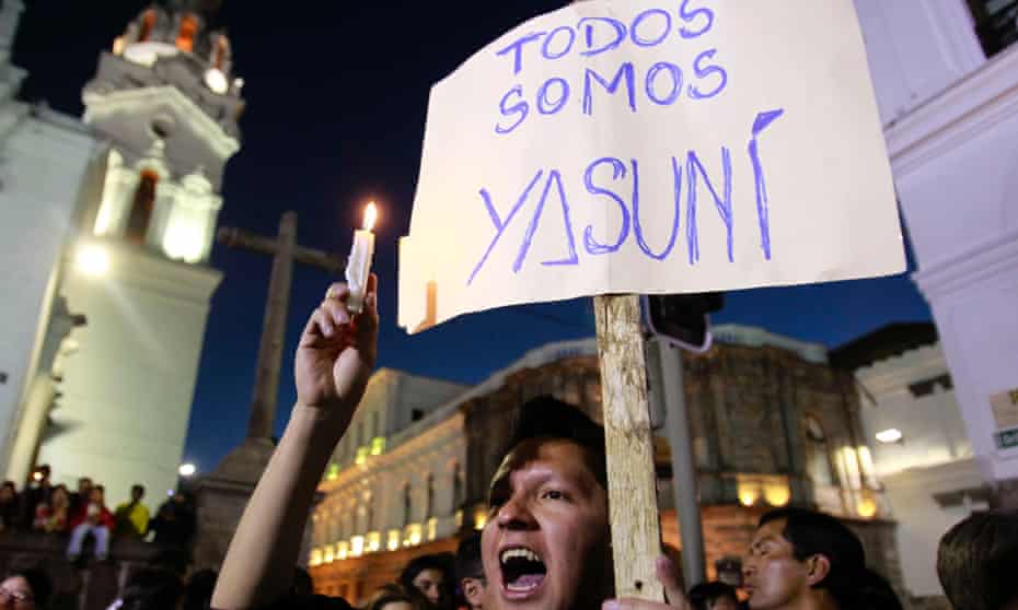 A young man holding a sign that reads in Spanish; "We are all Yasuni," joins others in a candlelight vigil in front of the Ecuadorean government palace in protest against thre president's decision to allow oil drilling in the Amazon reserve, Yasuni National Park