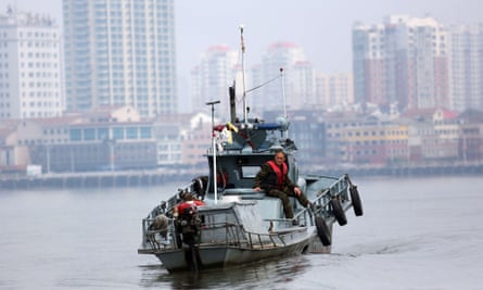 A North Korea soldier sits on a patrol boat on the Yalu River which separates the North Korean town of Sinuiju from the Chinese border town of Dandong.