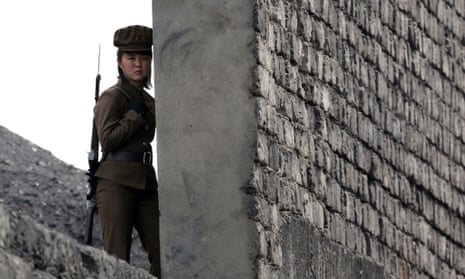 A North Korean soldier patrols the bank of the Yalu River which separates the North Korean town of Sinuiju from the Chinese border town of Dandong, on 26 April 2014.