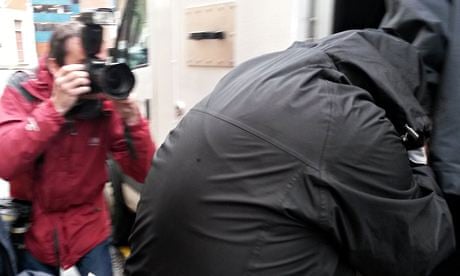 Robert Riley is taken from court after being jailed for offensive tweets about Ann Maguire's killing