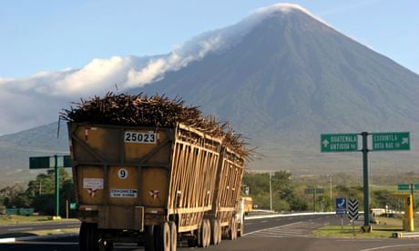 A truck loaded with cane drives to a sug