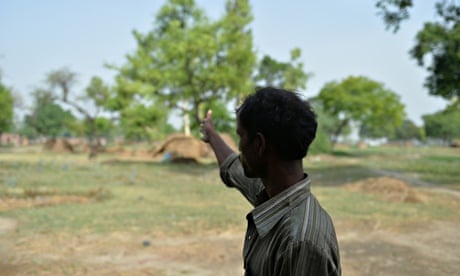 The father of one of the victims of gang-rape gestures towards the tree where his daughter was found