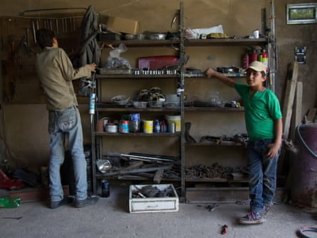Ali Allawi, 11, is working in a garage. He is not being paid, but in return for his labour is being trained as a mechanic