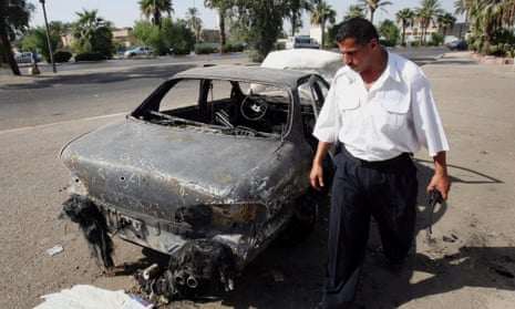 This 2007 photo shows an Iraqi traffic policeman inspects a car destroyed by a Blackwater security detail in al-Nisoor Square in Baghdad.