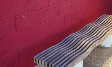 A wooden bench with a wavy seat to deter sleepers.