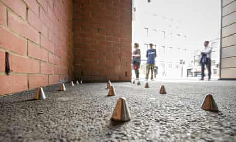 The inch-high conical spikes, with pedestrians in the background