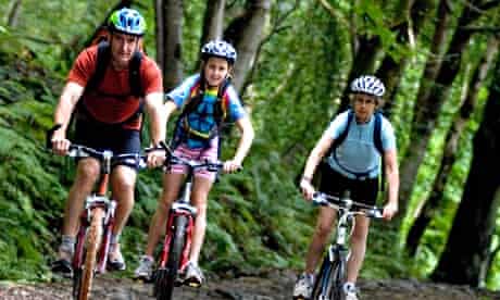 Group of three cyclists in Grizedale Forest Lake District UK
