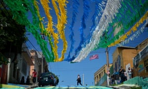 A woman crosses a road under street decorations in Manaus before England v Italy.