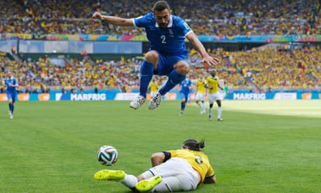 Greece's Giannis Maniatis leaps over a challenge by Colombia's Mario Yepes.