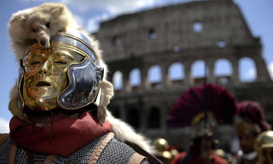 Men belonging to historical groups march dressed as ancient Romans during a parade in front of the coliseum to mark the anniversary of the legendary foundation of the eternal city in 753 B.C, in Rome on April 21, 2013.