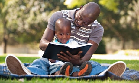Father reading with son (4-5) on lawn, Johannesburg, Gauteng Province, South Africa