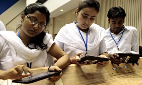A group of students try the 'Aakash' tablet computer during a news conference in New Delhi, India