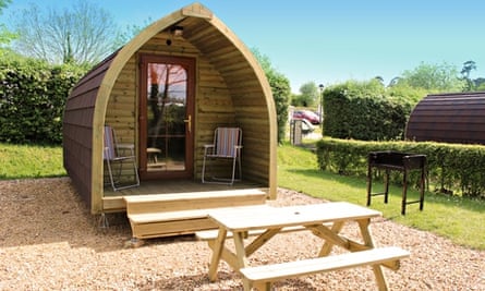 Wooden camping pod at Sandy Balls with picnic bench in front