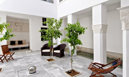 Courtyard with pillars, chairs, trees in Riad Sapphire in Marrakech