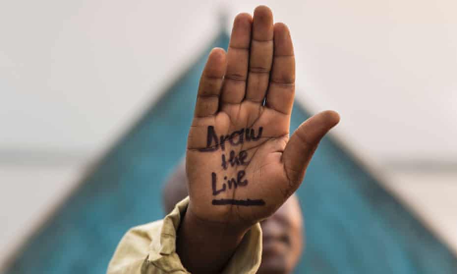A villager with 'Draw the Line' written on his hand in objection to any oil prospecting, exploration or  drilling posing in Virunga National Park, Democratic Republic of Congo, as part of WWF's 'Draw the Line' Campaign.