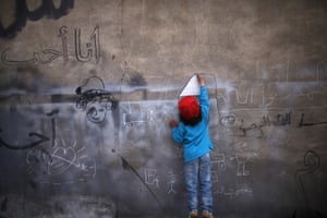 Child painting mural in a refugee camp in Jordan
